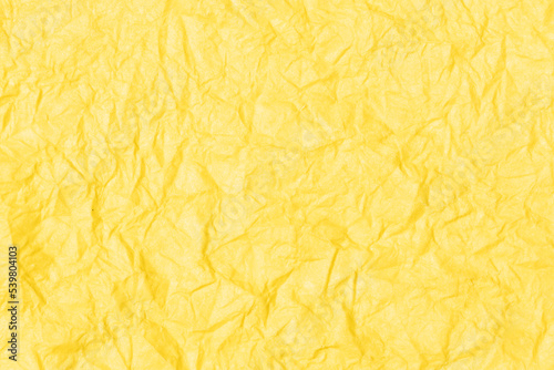 Crumpled paper abstract background texture. Yellow color. Full frame