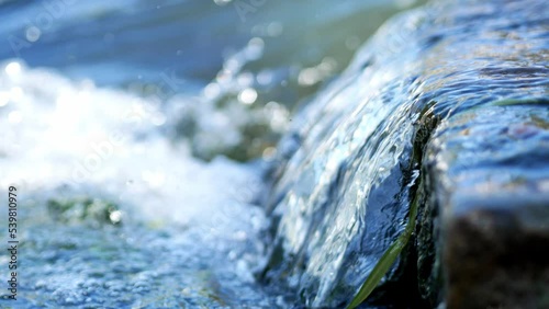 The rapid flow of the river near the dam, rapids, clear clear water close-up.