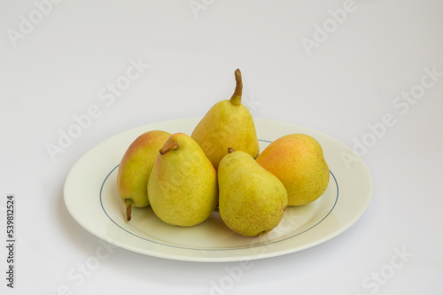 white opal glass plate with pears pear variety ercolina, isolated on white background