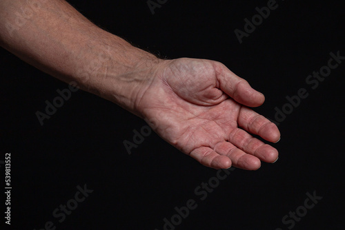 The outstretched hand of a caucasian man, isolated on black background.