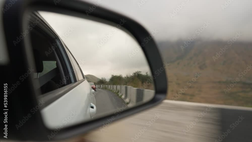 View from the side window of a car driving fast along the highway Past Beautiful Mountains. Travel trip and adventure concept. View from the side window of a car driving fast along the highway Past Beautiful Mountains. Travel trip and adventure concept.