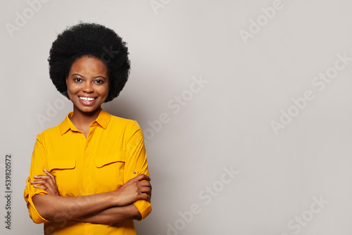 Cute friendly woman standing with crossed arms on white studio background
