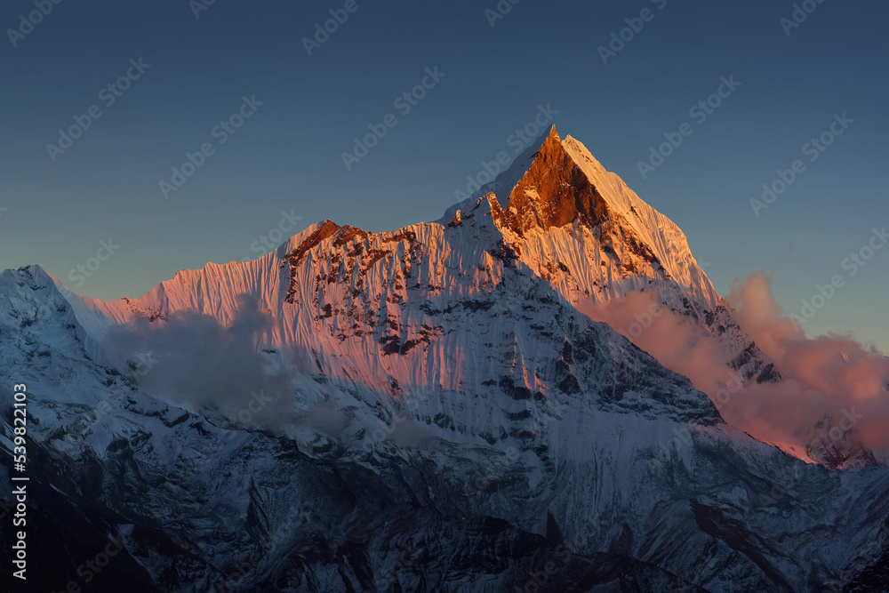 Covered by snow Mt. Machapuchare at sunset, view from Annapurna base camp.