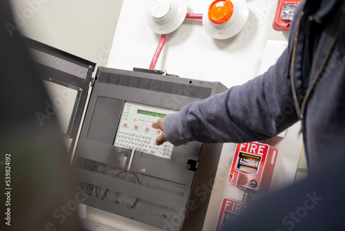 Pull station fire alarm system and mock sprinklers attached to a white wall used for training of security guards. 