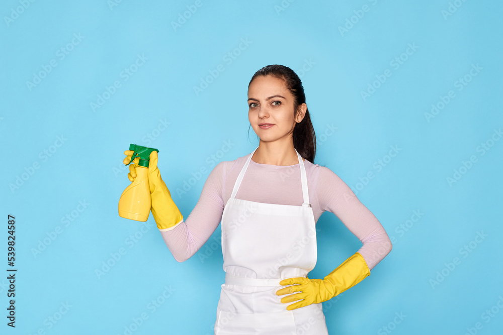 woman in rubber gloves and cleaner apron holding bucket of detergents