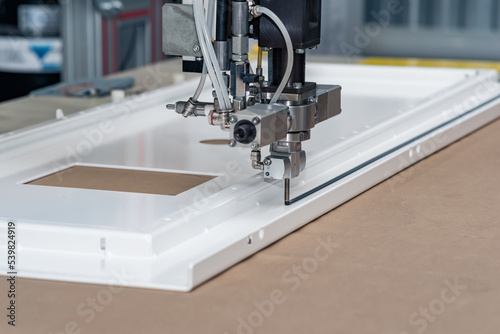 Фотография industrial robotic dosing dispenser machine applies a hardening sealant to the m