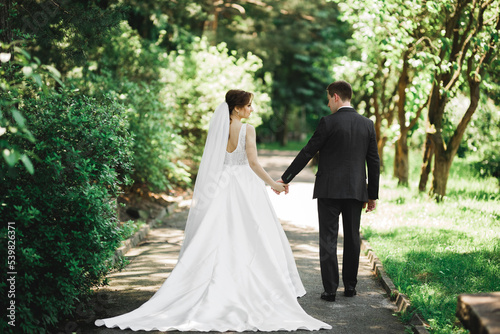 Happy wedding couple walking in a botanical park