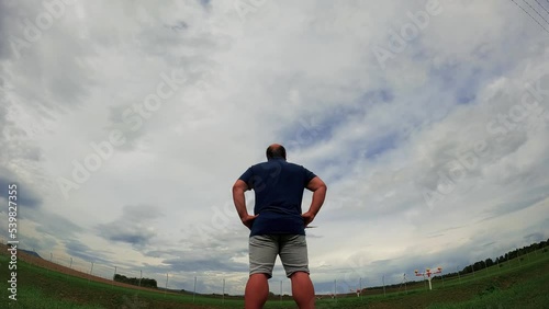 Man standing under landing aircraft, flying above head, Epic slow motion footage