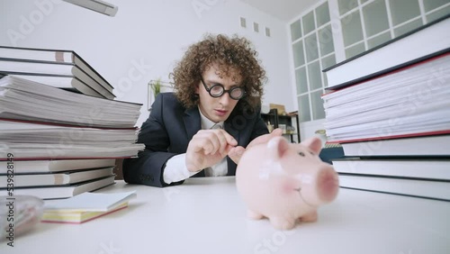 Funny office worker putting coins in piggy bank, low-paying job, underpaid photo