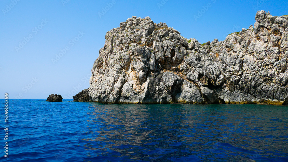 Secluded gray rock isolated on the claer blue sky 