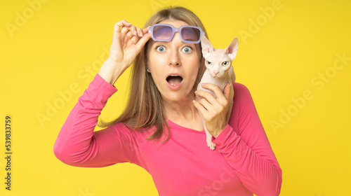 Фотография impressed shocked young attractive woman wearing red dress and holding sunglasse