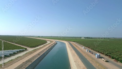 High angle drone rise of an irrigation canal with water in California's Central Valley