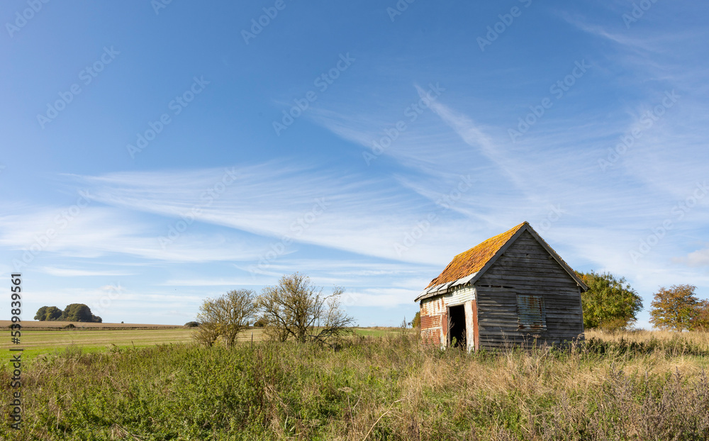 old farm building on agricultural land, open farmland blue skys