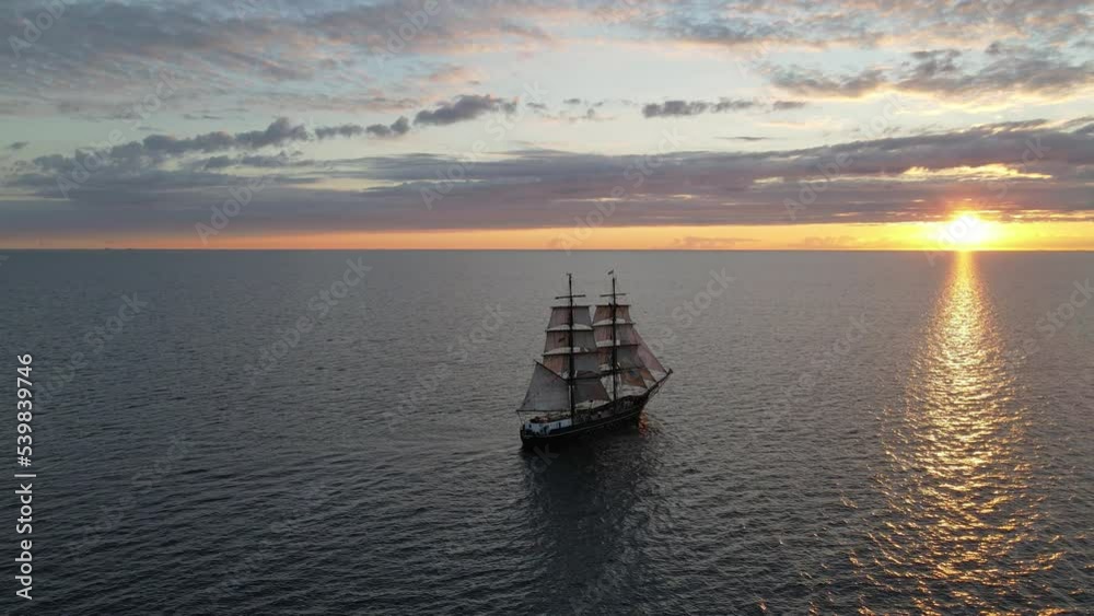 fast rotating aerial shot of a tall ship sailing into the sunset fast rotating aerial shot of a tall ship sailing into the sunset