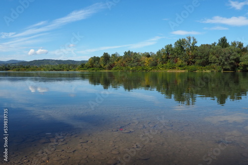 Drina river near the town of Banja Koviljaca, Serbia, view of the coast of Bosnia and Herzegovina. Rybnik on the Drina. The flow of water, blue sky, greenery on the opposite side of the river.