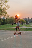 asian woman on skates in public park during sunset
