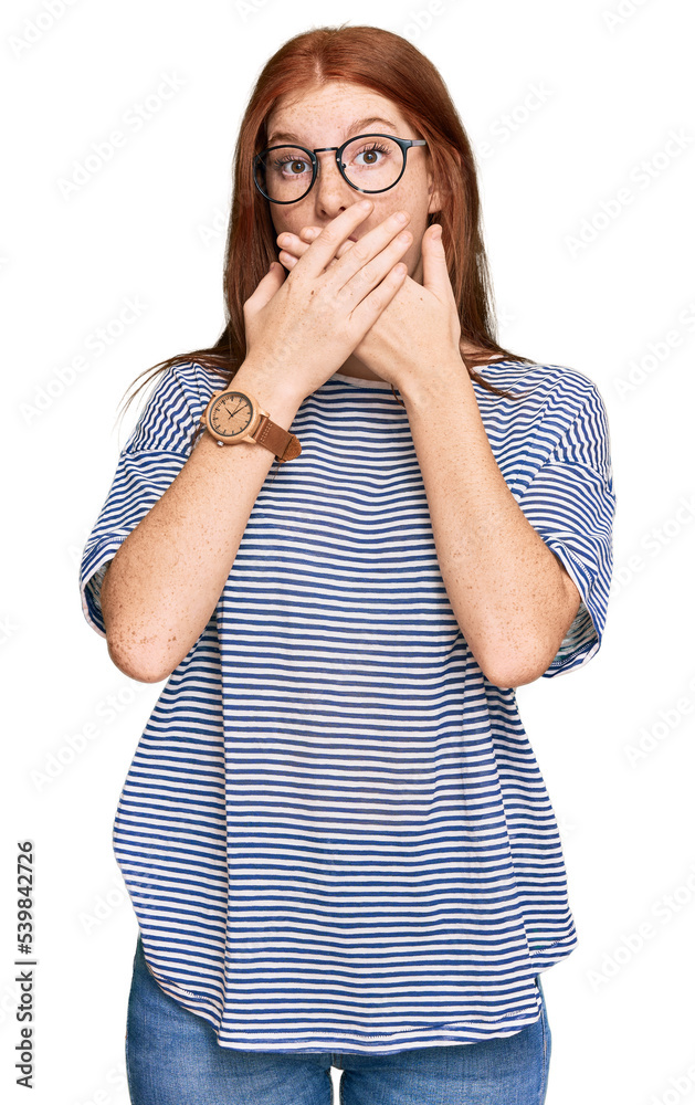 Young read head woman wearing casual clothes and glasses shocked covering mouth with hands for mistake. secret concept. Young read head woman wearing casual clothes and glasses shocked covering mouth with hands for mistake. secret concept.
