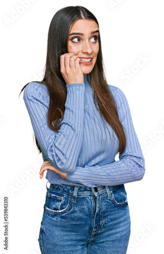 Young beautiful woman wearing casual winter sweater looking stressed and nervous with hands on mouth biting nails. anxiety problem.