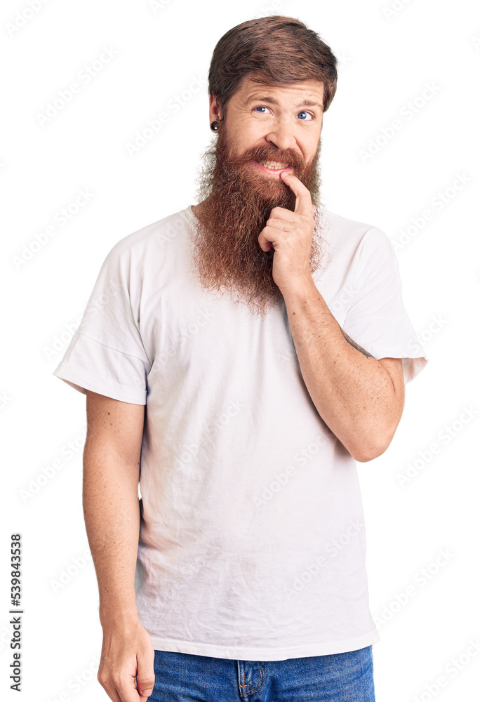 Handsome young red head man with long beard wearing casual white tshirt looking confident at the camera with smile with crossed arms and hand raised on chin. thinking positive. Handsome young red head man with long beard wearing casual white tshirt looking confident at the camera with smile with crossed arms and hand raised on chin. thinking positive.