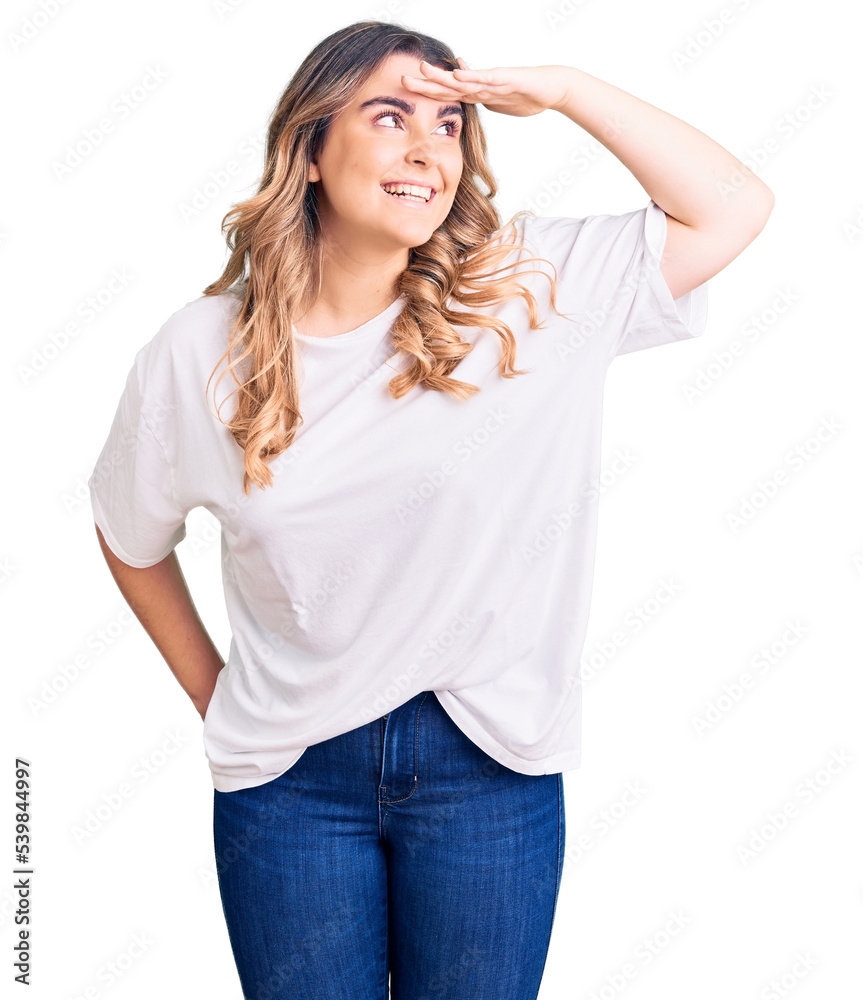 Young caucasian woman wearing casual clothes very happy and smiling looking far away with hand over head. searching concept.