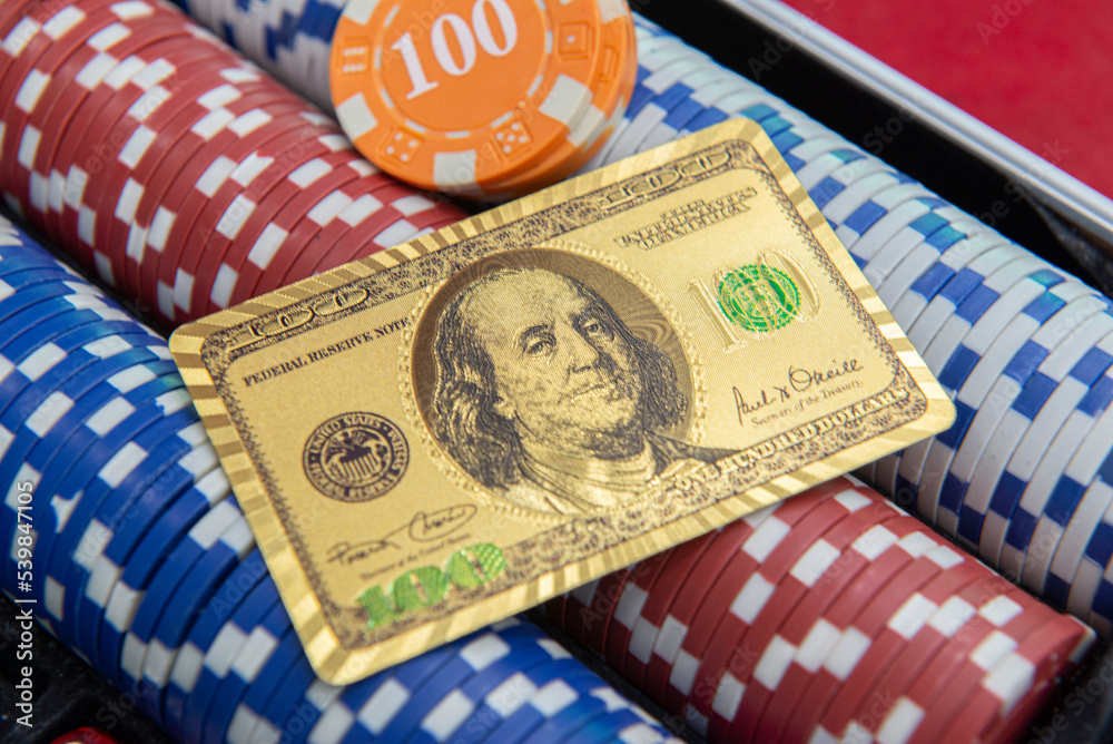 Obraz premium Gold playing cards and $100 bill format on poker chips