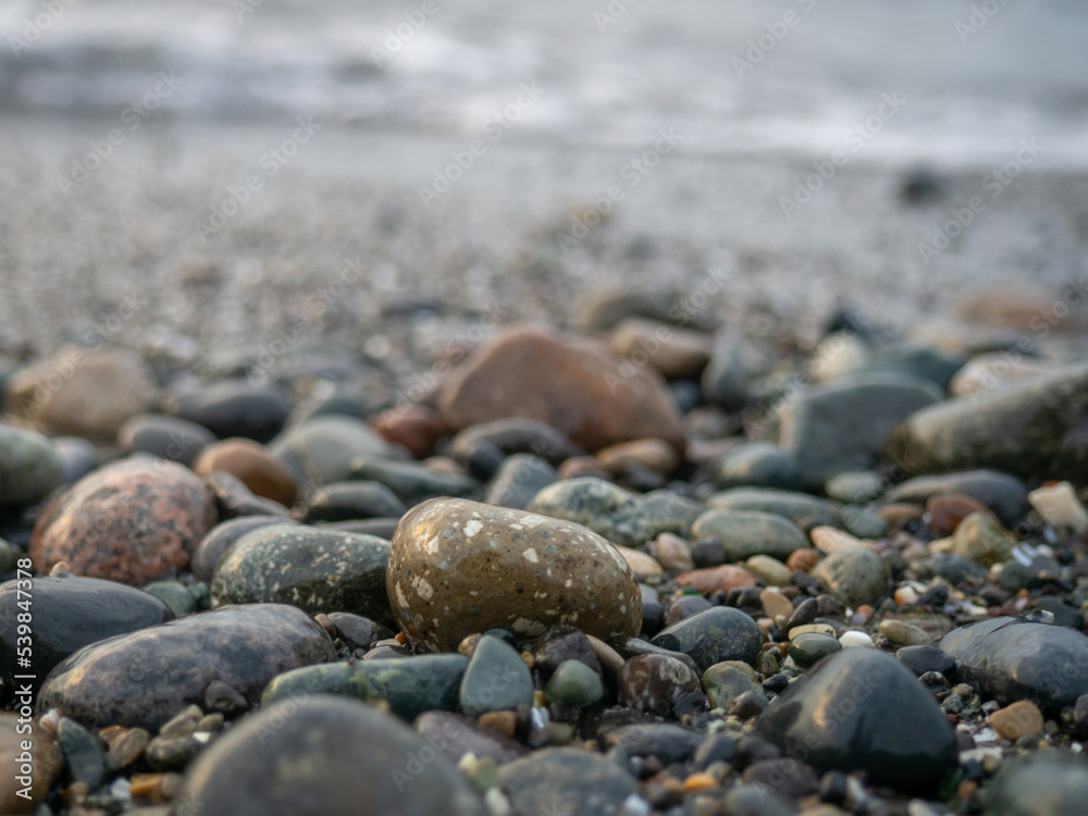 Pebbles on the seashore close-up. Rocky beach. Stones close-up with bokeh. Gray natural background. The concept of rest on the seashore. Autumn on the seashore. Waves and wet pebbles Pebbles on the seashore close-up. Rocky beach. Stones close-up with bokeh. Gray natural background. The concept of rest on the seashore. Autumn on the seashore. Waves and wet pebbles