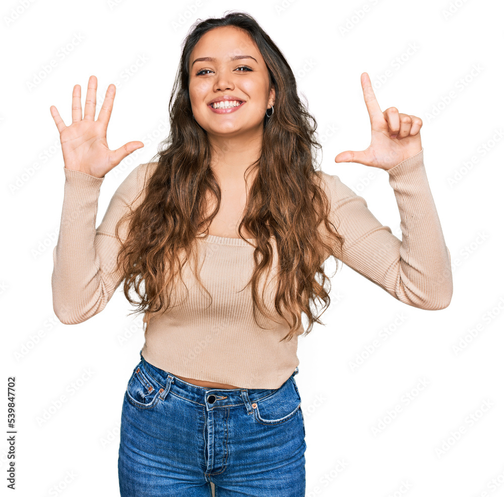 Young hispanic girl wearing casual clothes showing and pointing up with fingers number seven while smiling confident and happy. Young hispanic girl wearing casual clothes showing and pointing up with fingers number seven while smiling confident and happy.