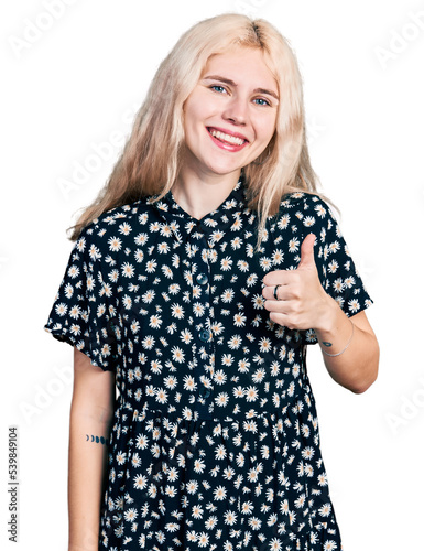 Young caucasian woman together doing happy thumbs up gesture with hand. approving expression looking at the camera showing success.