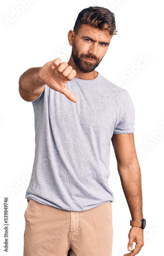 Young hispanic man wearing casual clothes looking unhappy and angry showing rejection and negative with thumbs down gesture. bad expression.
