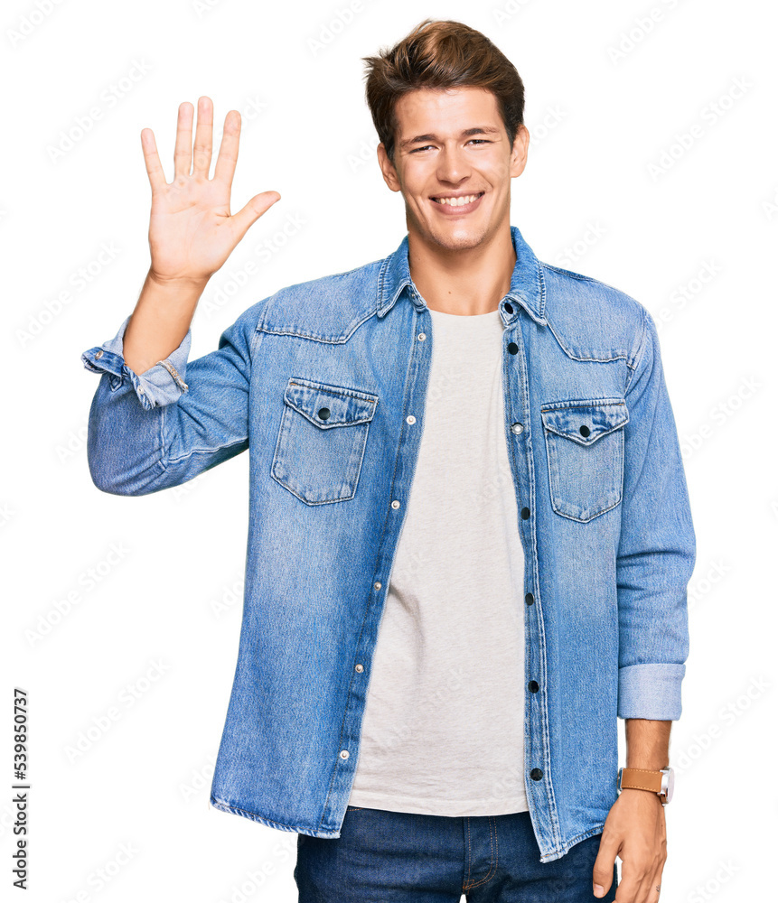 Handsome caucasian man wearing casual denim jacket showing and pointing up with fingers number five while smiling confident and happy. Handsome caucasian man wearing casual denim jacket showing and pointing up with fingers number five while smiling confident and happy.
