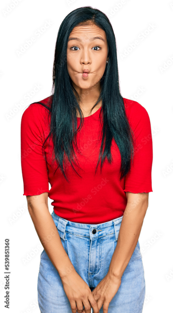 Obraz premium Beautiful hispanic woman wearing casual clothes making fish face with lips, crazy and comical gesture. funny expression.