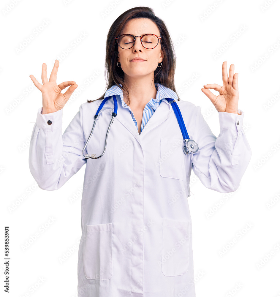 Young beautiful woman wearing doctor stethoscope and glasses relax and smiling with eyes closed doing meditation gesture with fingers. yoga concept. Young beautiful woman wearing doctor stethoscope and glasses relax and smiling with eyes closed doing meditation gesture with fingers. yoga concept.