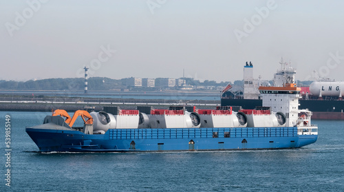 Port of Rotterdam, the Netherlands - 10 05 2022: Heavy load carrier with the cargo of wind farm components on board entering the European port photo