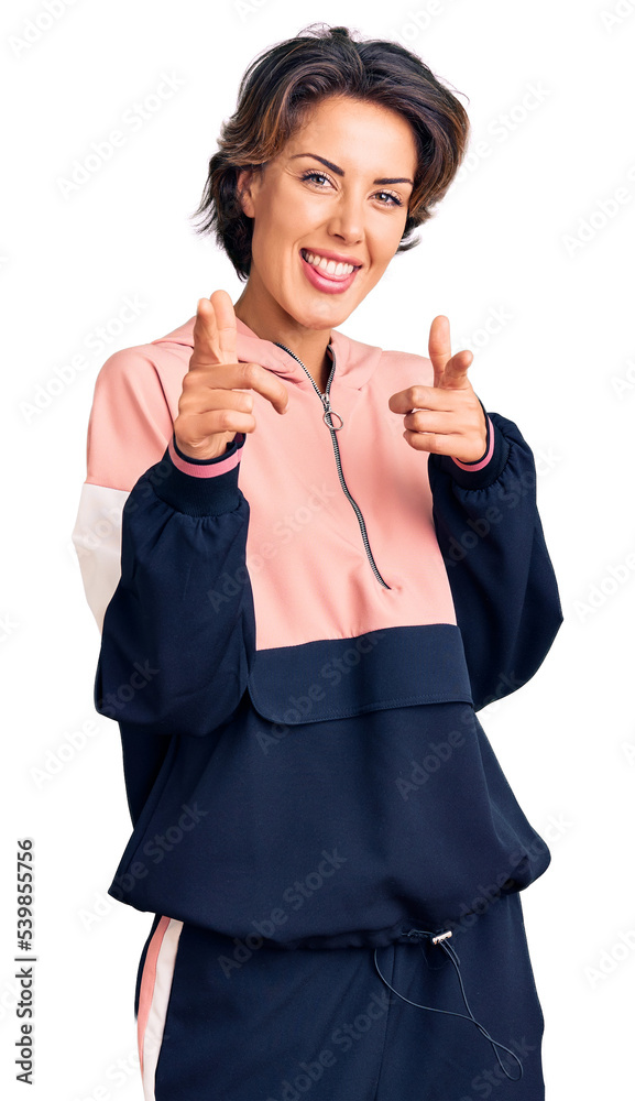 Young beautiful woman wearing sportswear pointing fingers to camera with happy and funny face. good energy and vibes. Young beautiful woman wearing sportswear pointing fingers to camera with happy and funny face. good energy and vibes.
