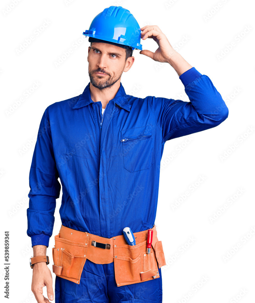 Young handsome man wearing worker uniform and hardhat doing stop sing with palm of the hand. warning expression with negative and serious gesture on the face. Young handsome man wearing worker uniform and hardhat doing stop sing with palm of the hand. warning expression with negative and serious gesture on the face.