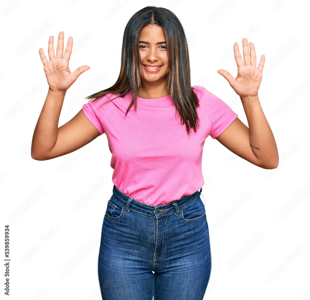 Young latin girl wearing casual clothes showing and pointing up with fingers number ten while smiling confident and happy. Young latin girl wearing casual clothes showing and pointing up with fingers number ten while smiling confident and happy.