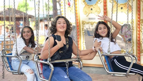 Three young girls on a ride on wave swinger photo