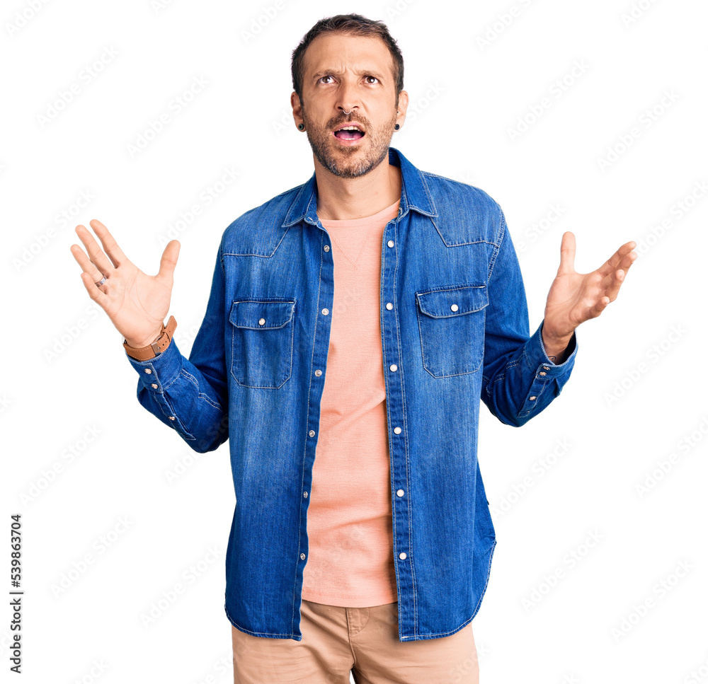 Young handsome man wearing casual clothes crazy and mad shouting and yelling with aggressive expression and arms raised. frustration concept. Young handsome man wearing casual clothes crazy and mad shouting and yelling with aggressive expression and arms raised. frustration concept.