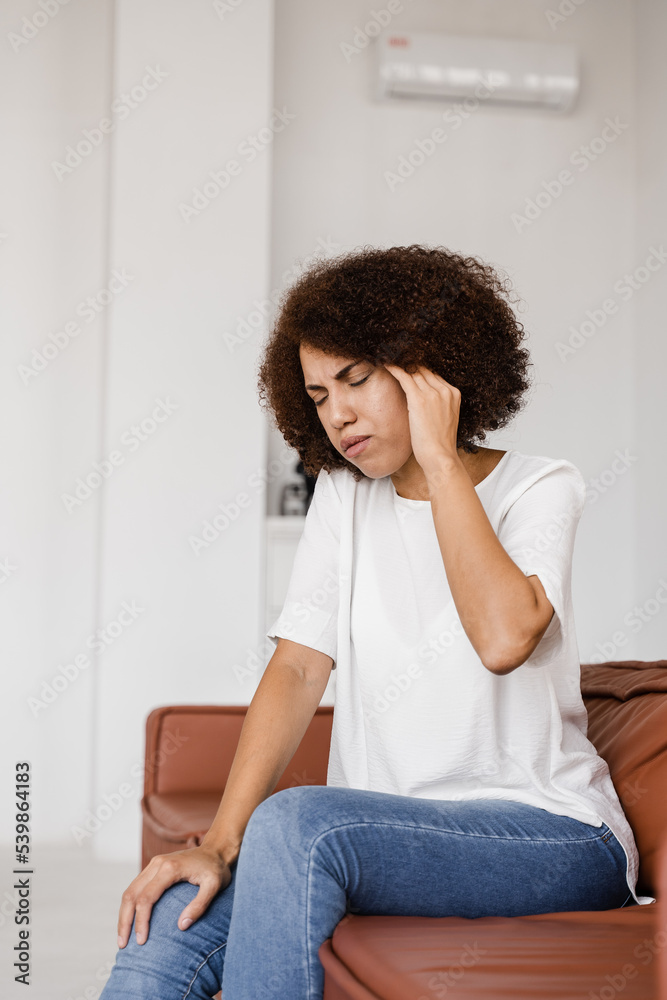 Depressed girl with migraine headache. Sad african american woman touches temples because of stress and despair in her life. Problems in life. Depressed girl with migraine headache. Sad african american woman touches temples because of stress and despair in her life. Problems in life.