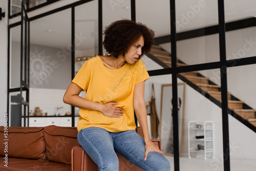 Ulcer or gastritis stomach ache. Sick african american girl hold abdomen because it hurts. Pancreatitis disease of pancreas becomes inflamed.