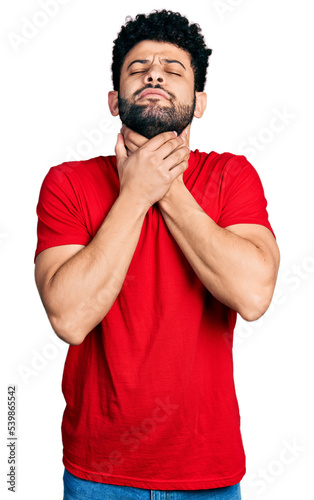 Young arab man with beard wearing casual red t shirt shouting and suffocate because painful strangle. health problem. asphyxiate and suicide concept.