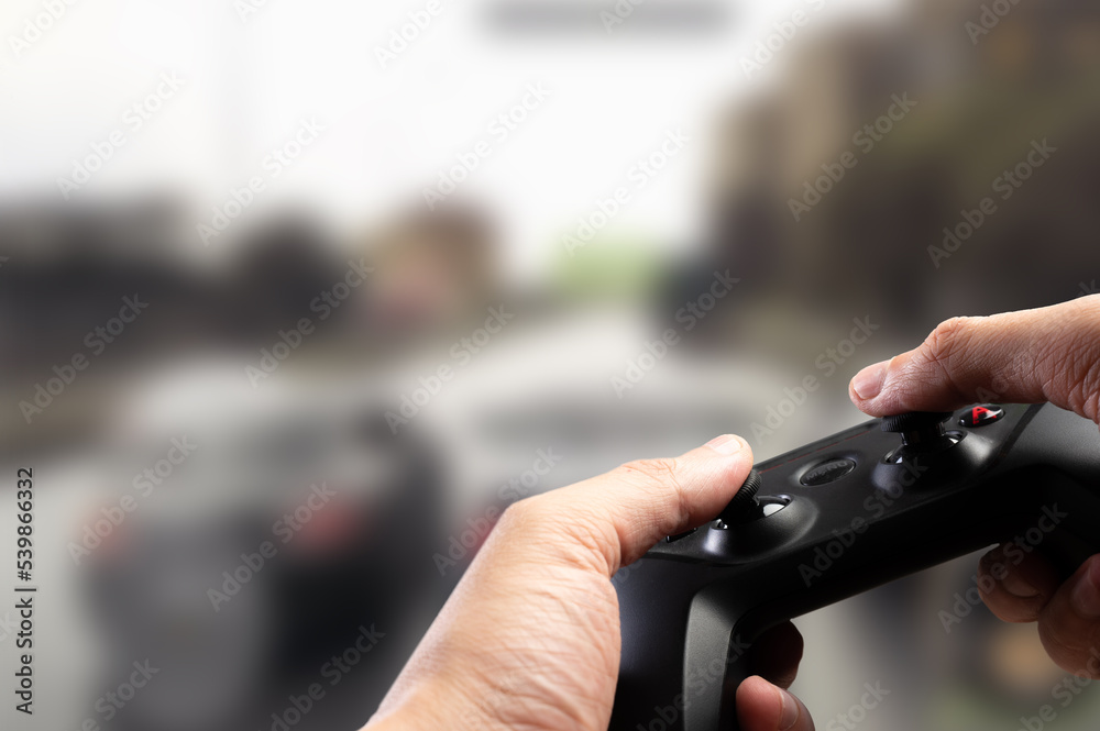 A joystick in the hands of a gamer against the background of a video game on a large TV screen, a personal computer monitor. Online games, hobby, cyberspace, esports. A joystick in the hands of a gamer against the background of a video game on a large TV screen, a personal computer monitor. Online games, hobby, cyberspace, esports.