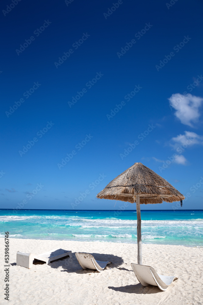 Sun umbrella ans sunbed on white sandy beach with turquoise ocean water. Caribbean sea travel destination. Bounty and pristine nature for vacation