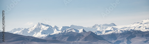 Panorama of the mountain peaks of the Caucasus Range with glaciers and snow in the highlands, a cloudless summer day