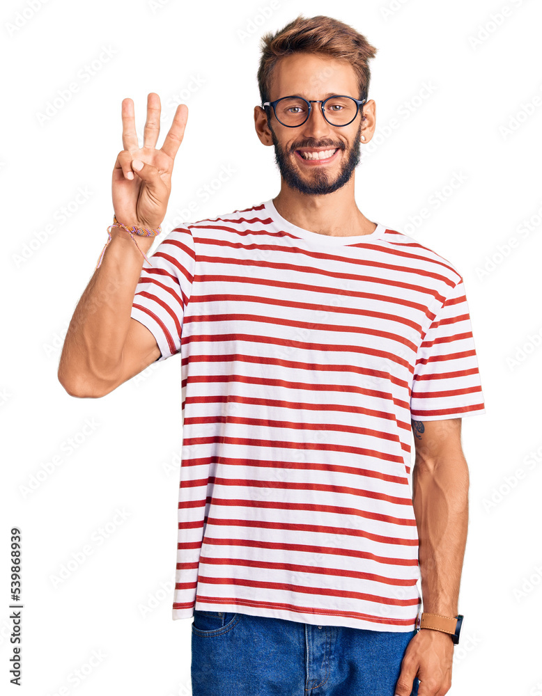 Naklejka premium Handsome blond man with beard wearing casual clothes and glasses showing and pointing up with fingers number three while smiling confident and happy.