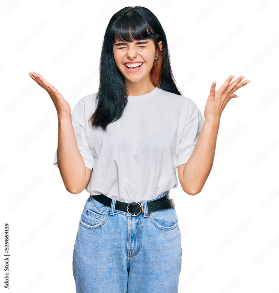 Young hispanic girl wearing casual clothes celebrating mad and crazy for success with arms raised and closed eyes screaming excited. winner concept Young hispanic girl wearing casual clothes celebrating mad and crazy for success with arms raised and closed eyes screaming excited. winner concept