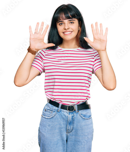 Young hispanic girl wearing casual clothes showing and pointing up with fingers number ten while smiling confident and happy.