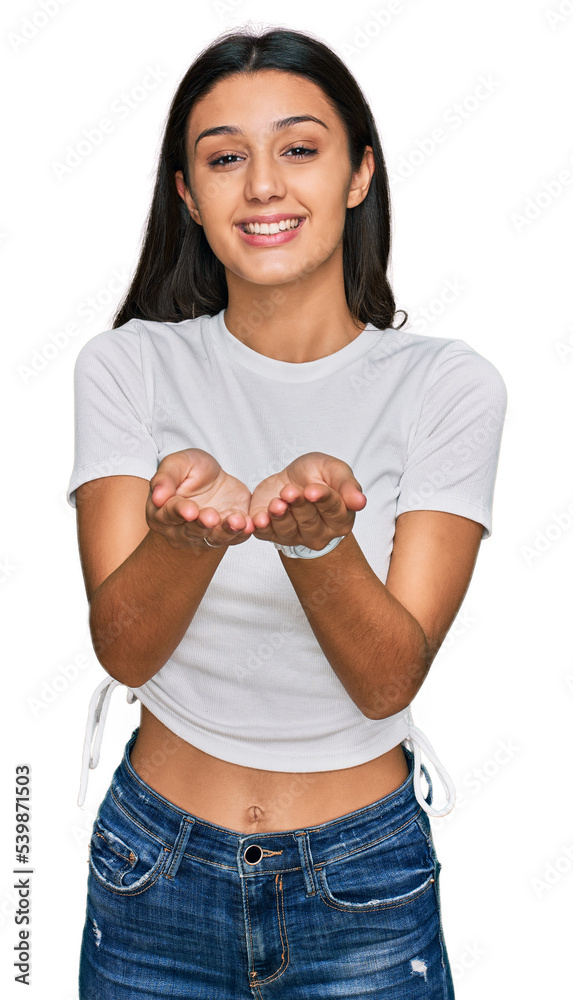 Young hispanic girl wearing casual white t shirt smiling with hands palms together receiving or giving gesture. hold and protection Young hispanic girl wearing casual white t shirt smiling with hands palms together receiving or giving gesture. hold and protection