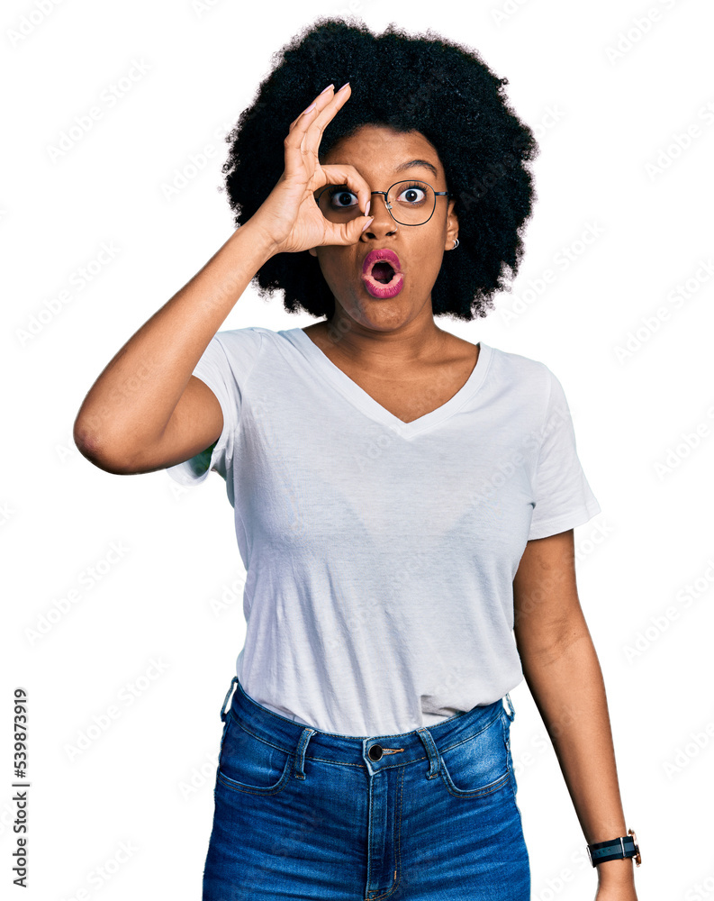 Young african american woman wearing casual white t shirt doing ok gesture shocked with surprised face, eye looking through fingers. unbelieving expression. Young african american woman wearing casual white t shirt doing ok gesture shocked with surprised face, eye looking through fingers. unbelieving expression.