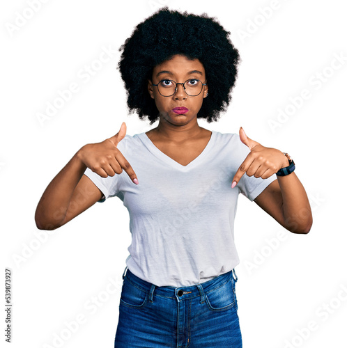 Young african american woman wearing casual white t shirt pointing down looking sad and upset, indicating direction with fingers, unhappy and depressed.